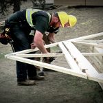 Construction workers preparing roof joists